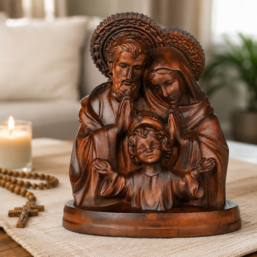Holy Family wood carving displayed on a living room table beside a rosary and candle