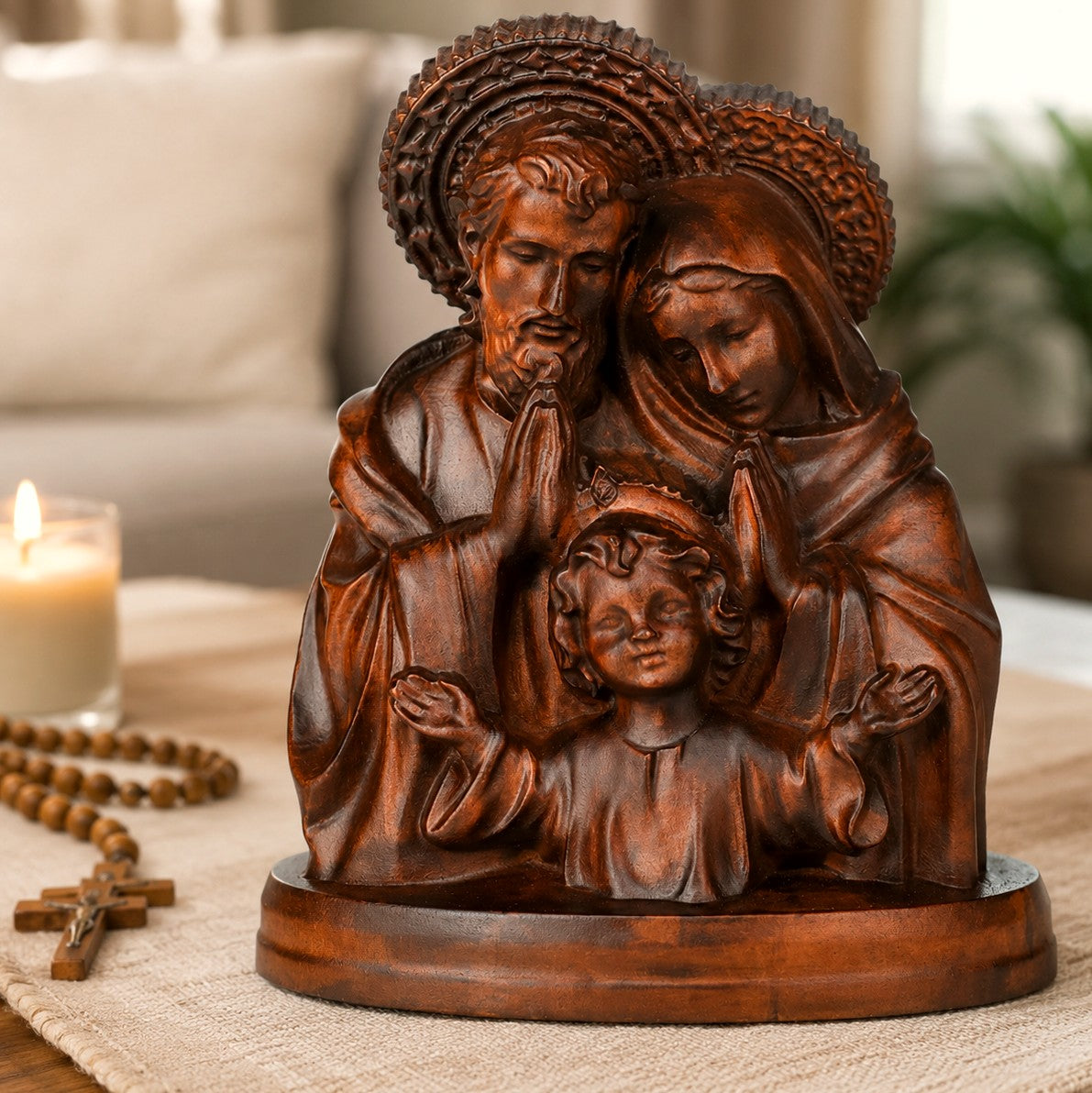 Holy Family wood carving displayed on a living room table beside a rosary and candle