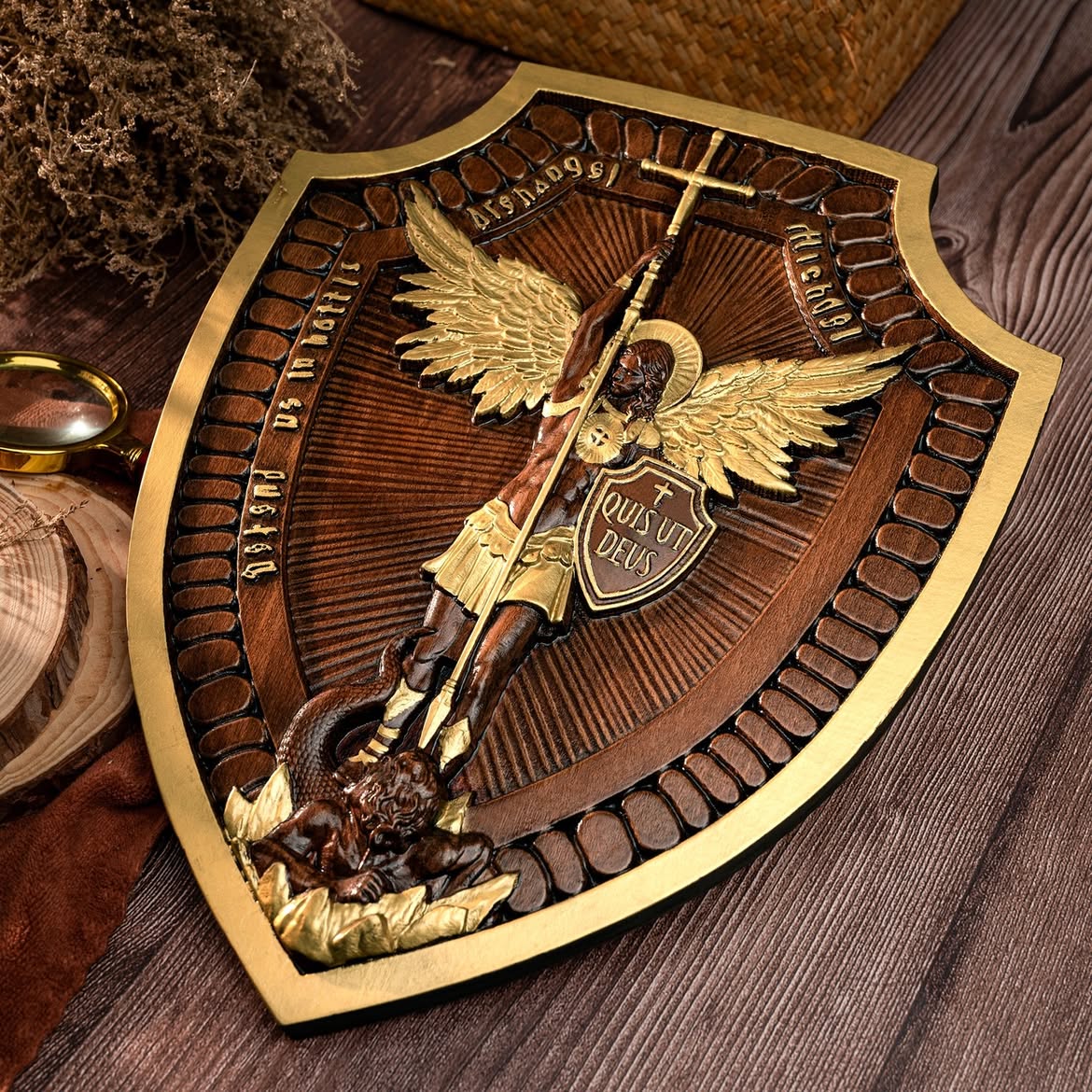 The Michael Shield on a table with pinecones and winter greens