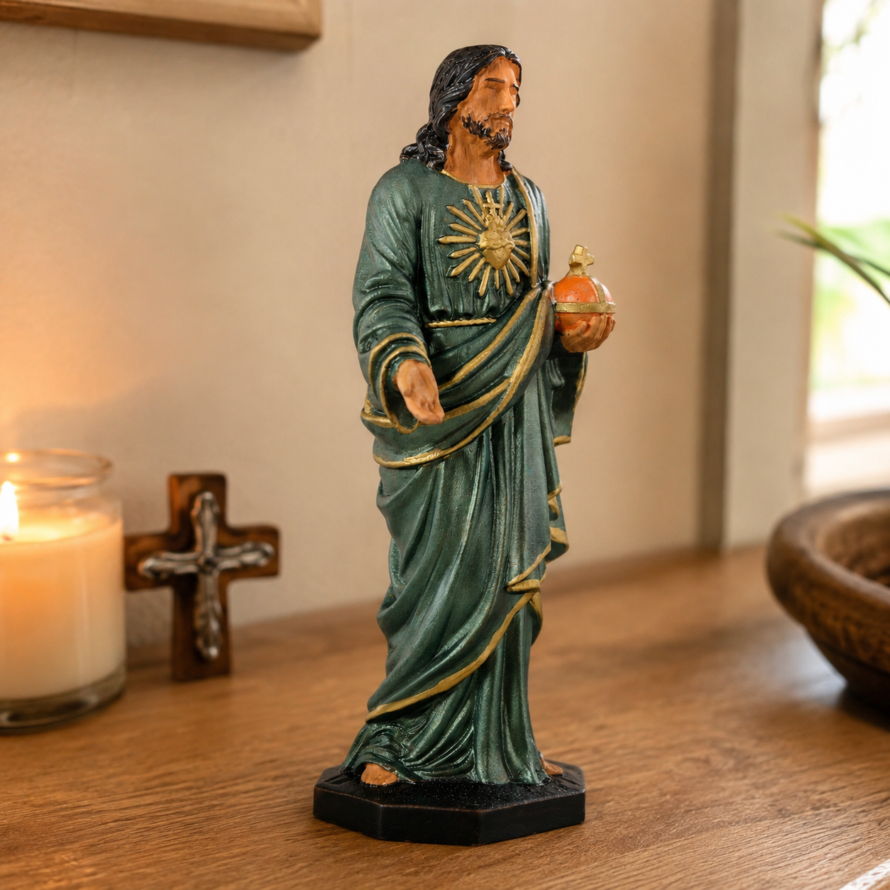 Hand-painted Sacred Heart statue on a bedside table by candlelight