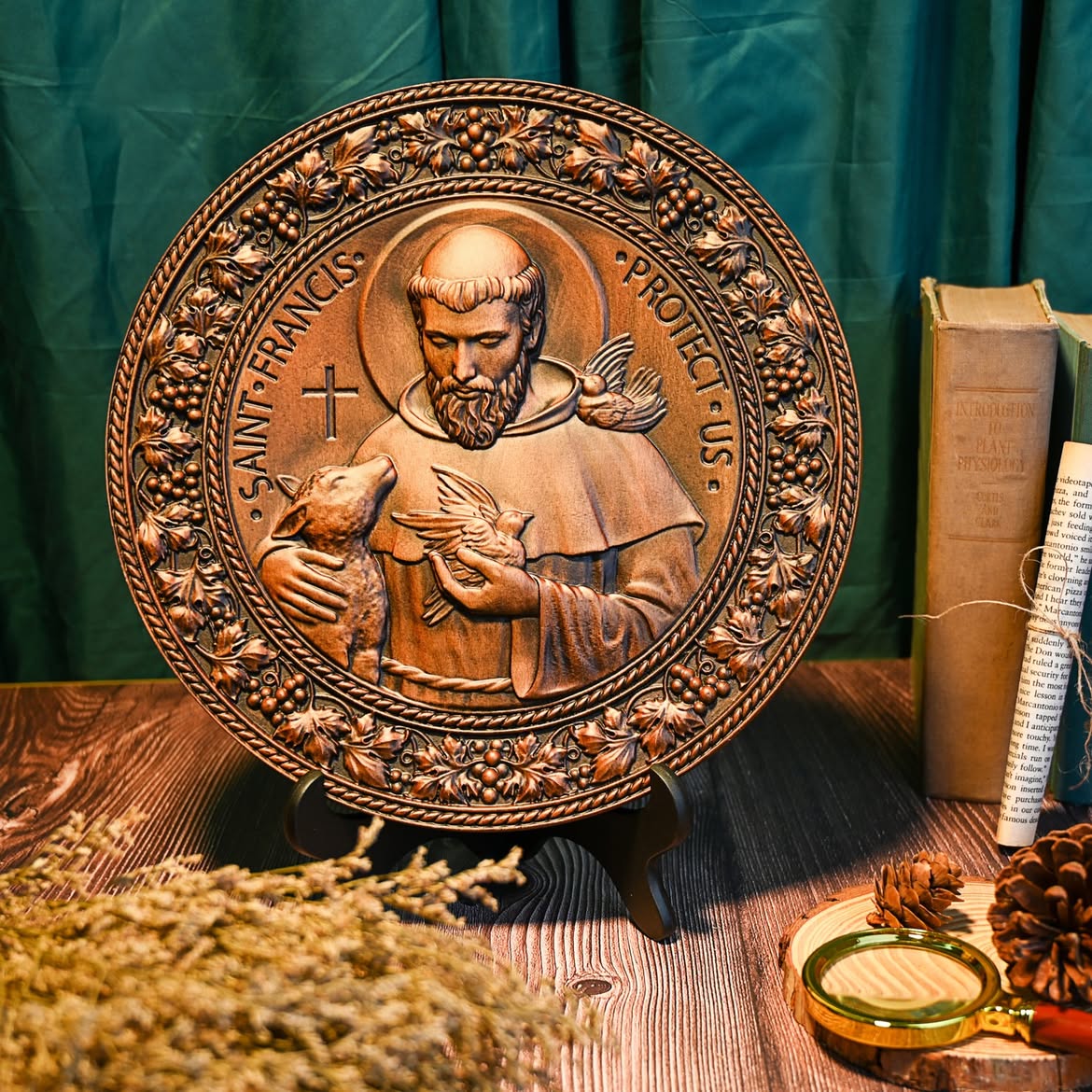 St. Francis medallion on a stand against a green drape