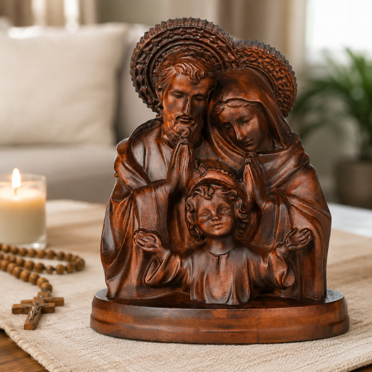 The Holy Family carving on a table with a rosary and candle