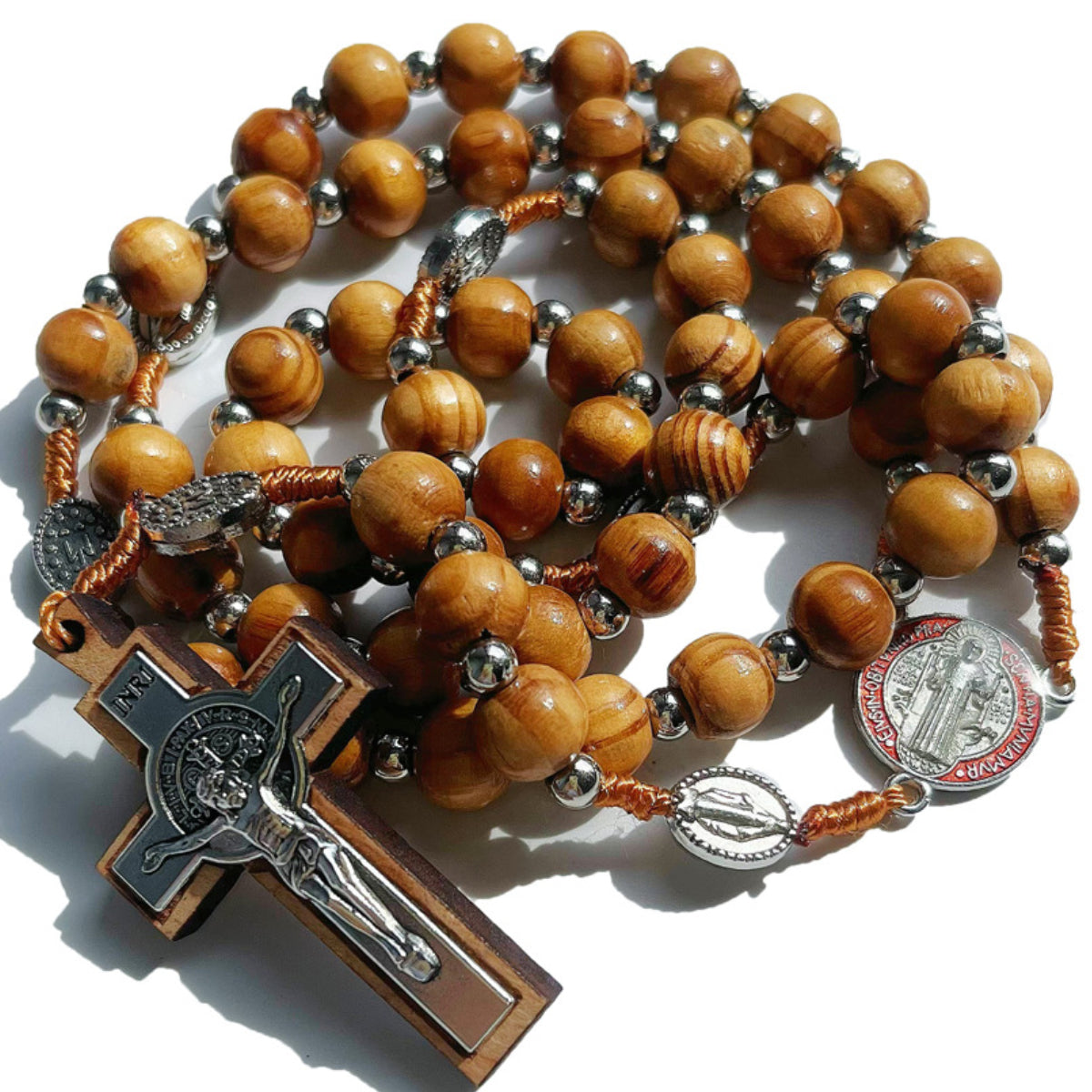 The St. Benedict rosary coiled, showing the carved wood beads and medal