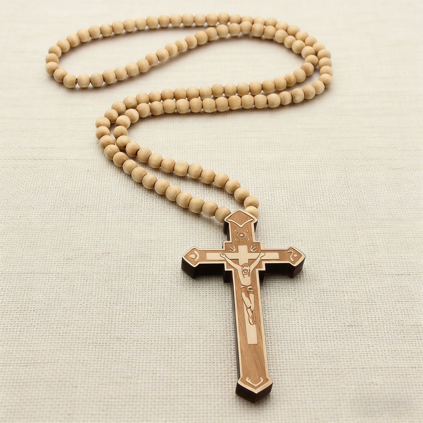 Natural wooden bead rosary lying on linen