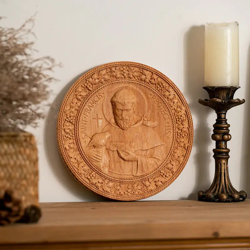 The St. Francis Medallion in natural beech on a mantel beside a candlestick