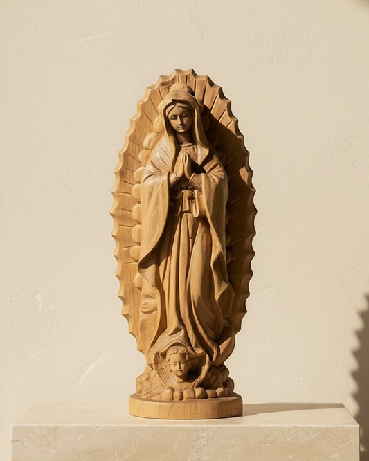 Our Lady of Guadalupe in beechwood on a travertine plinth, the light casting her rays across the limewash wall